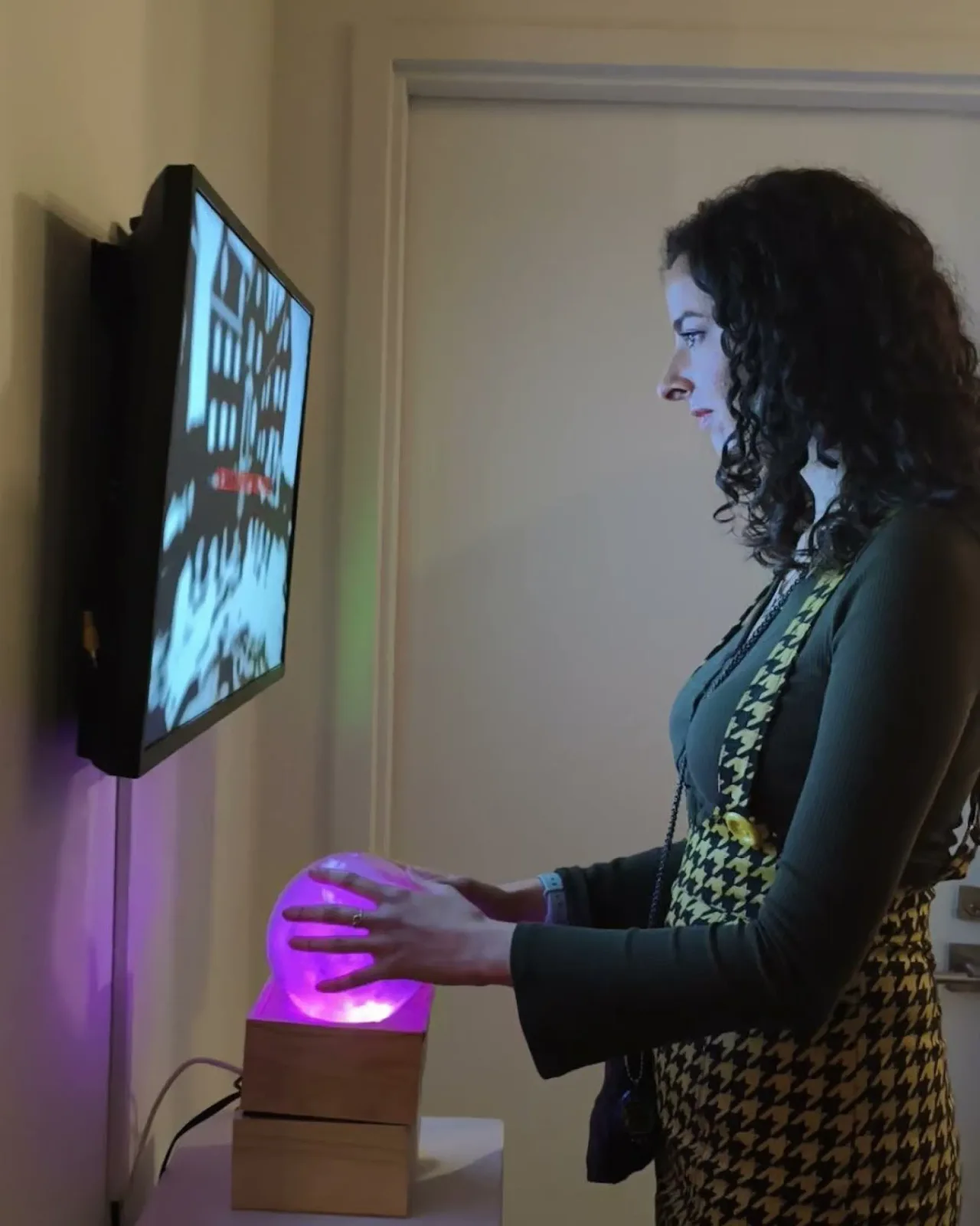 Visitor reaching toward the illuminated crystal ball of Vibe Altar at Pen + Brush Gallery, New York, 2026.