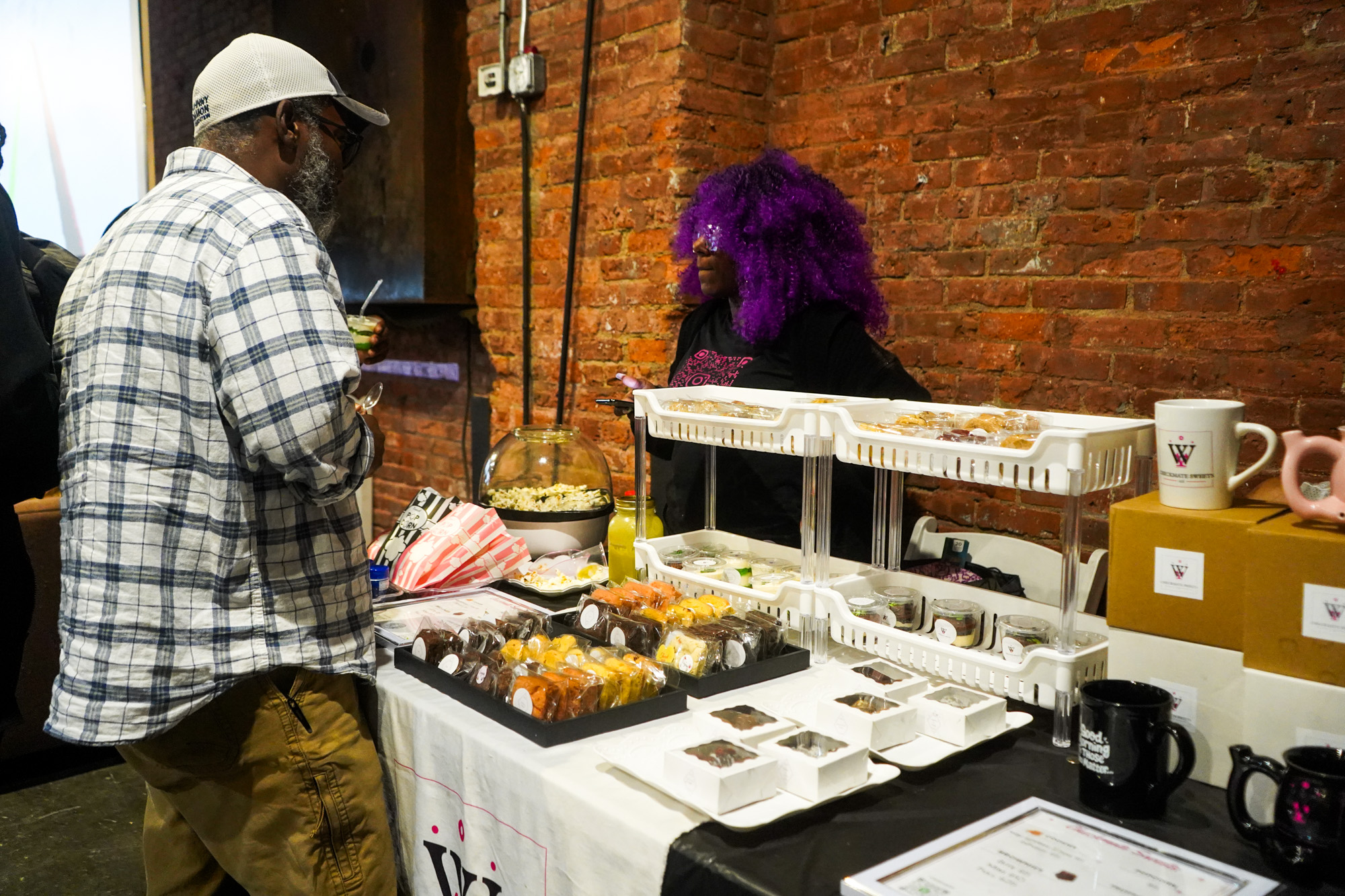 Vendor at the food table chatting with a guest